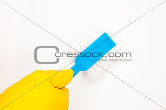 Hand in rubber glove using scrubbing brush