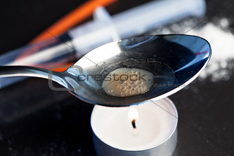 Heroin being cooked in a spoon over a candle