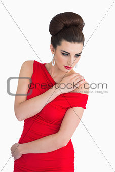 Woman in red dress holding her shoulder