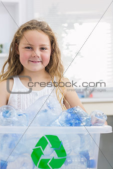 Little girl carrying box full of empty plastic bottles