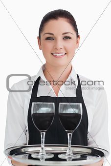 Smiling waitress holding two glasses of wine