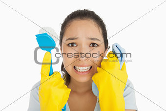 Distressed woman holding cloth and scrubbing brush