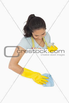 Smiling woman in gloves cleaning white surface