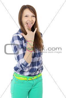 Teenage girl shows tongue and makes hand horns. Mint-colored pan