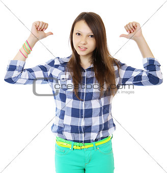 Young teen girl pointing behind with her thumb. Young woman in a