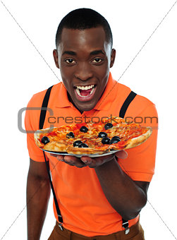 Boy in uniform offering pizza