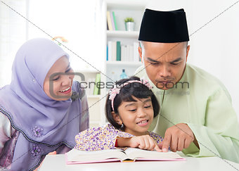 Malay Muslim parents teaching child