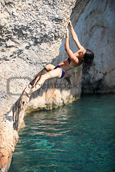 Young female rock climber on cliff
