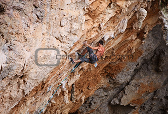 Rock climber struggling his way up