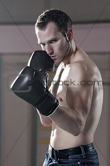Waist-up of male boxer in gym