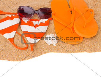 orange sandals and swimming siut on sand