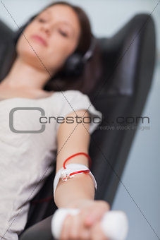 Patient listening to music while giving her blood in a hospital
