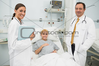 Female and male doctor standing next to a woman patient