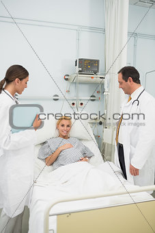 Doctors standing next to a patient