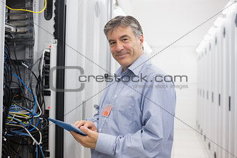 Smiling man doing maintenance on servers