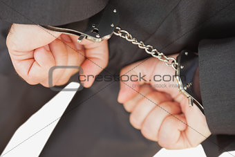 Businessman with handcuffs clencing fists
