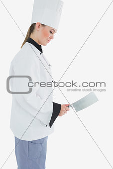 Chef holding meat cleaver as she smiles