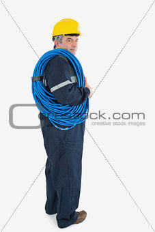 Portrait of mature repairman wearing hardhat with cable