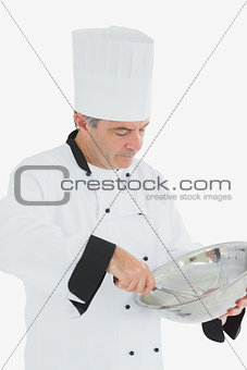 Chef using whisk and mixing bowl