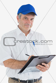 Confident courier man writing on clipboard