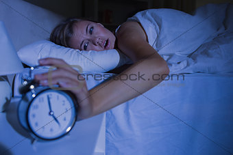 Awakening woman stopping her alarm clock