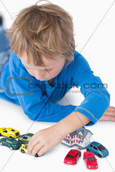 Closeup of boy playing with playhouse and toy cars