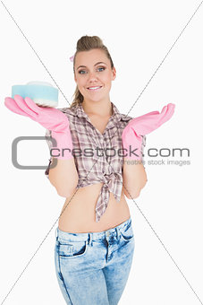 Portrait of smiling woman holding soap suds over sponge