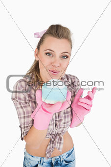 Portrait of woman blowing soap suds over sponge