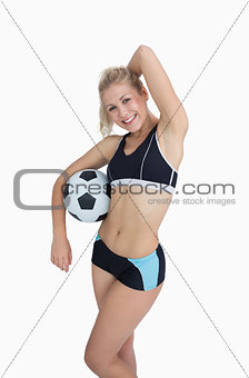 Sporty woman with football posing over white background