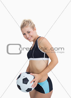 Portrait of happy woman in sportswear with football