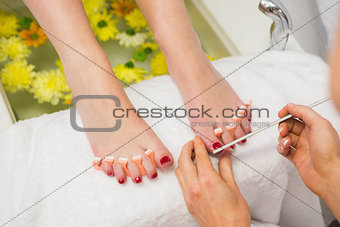 Woman polishing toe nails at spa center
