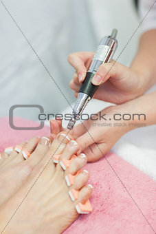 Hands removing callus at feet