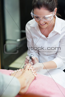 Nail technician removing callus at feet
