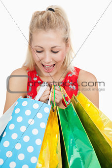 Cute excited woman looking into her shopping bags