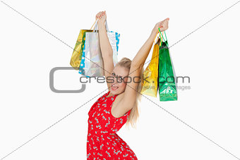 Portrait of cute excited woman holding up her shopping bags