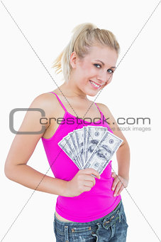 Portrait of happy woman holding fanned us banknotes