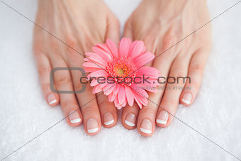 Flower on french manicured fingers at spa center