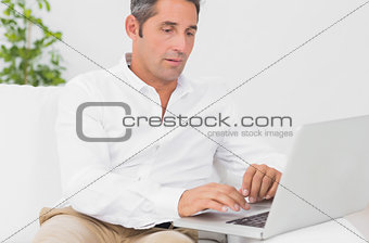 Serious man using his laptop