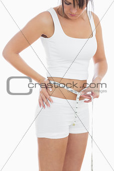 Young woman measuring waist