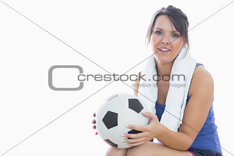 Portrait of happy woman in sportswear holding football
