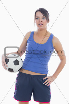Portrait of young woman in sportswear with football