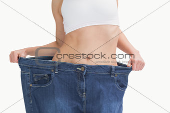 Midsection of female wearing old pants after losing weight