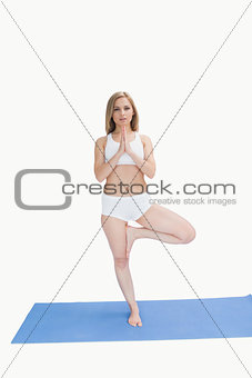 Portrait of young woman standing in praying position