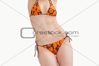 Midsection of young woman posing in bikini