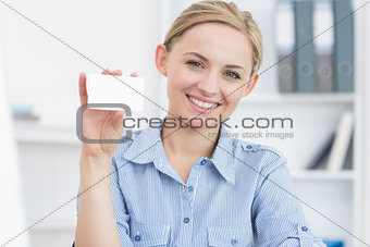 Female executive holding blank card at office