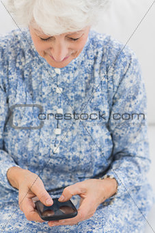 Elderly smiling woman using a smartphone