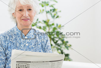 Elderly calm woman reading newspapers