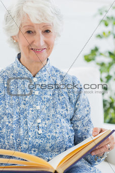 Elderly smiling woman with photo album