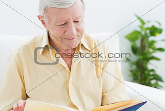Elderly smiling man watching his album