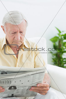 Elderly focused man reading newspapers